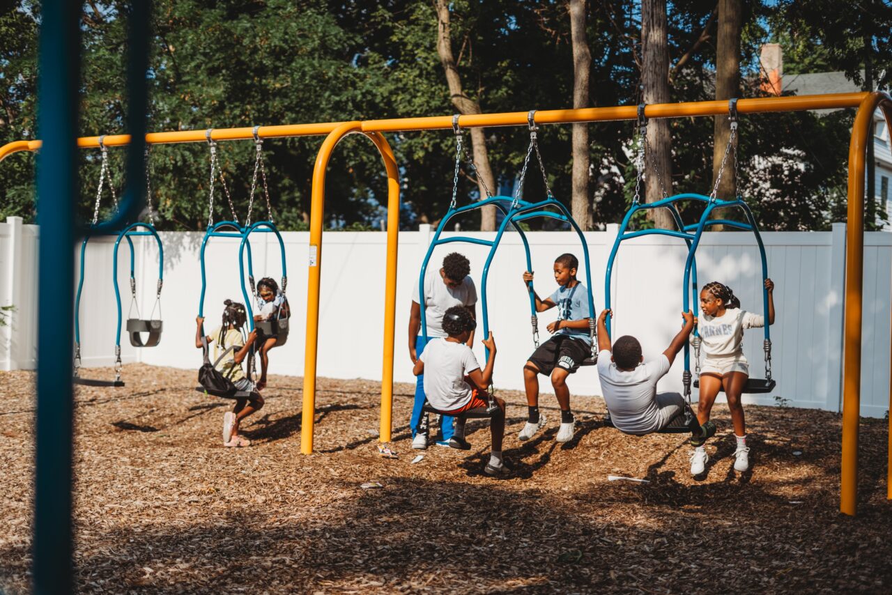 Children playing on the swings at the new intergenerational playground